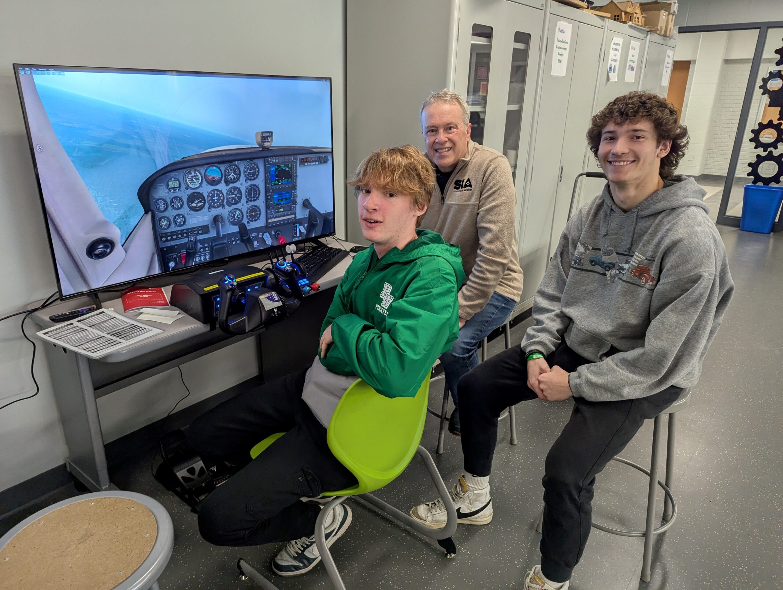 Port Washington High School students posing with Joe Canepa and their new flight simulator